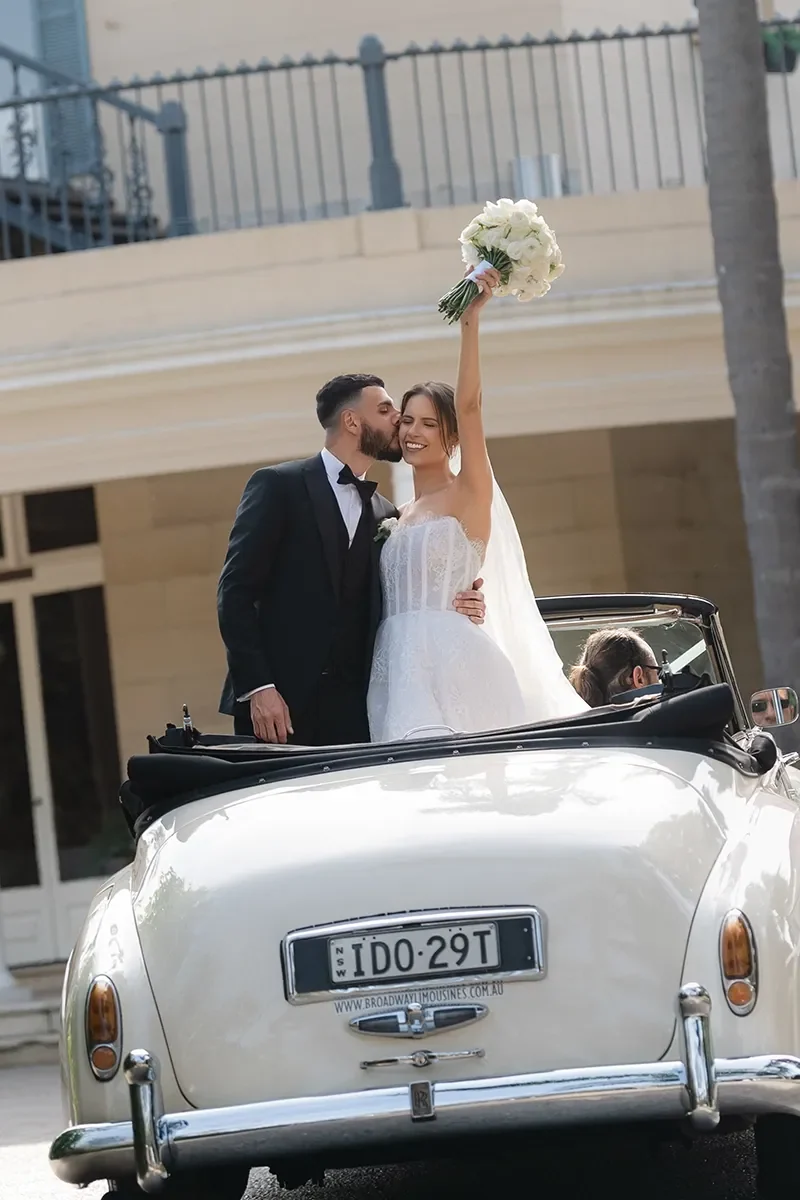 A couple on their wedding day at Oatlands Estate with a vintage car