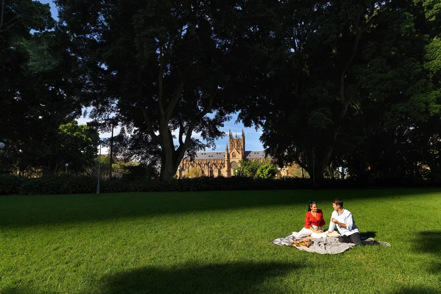 A couple in Hyde Park beside St Mary's Cathedral