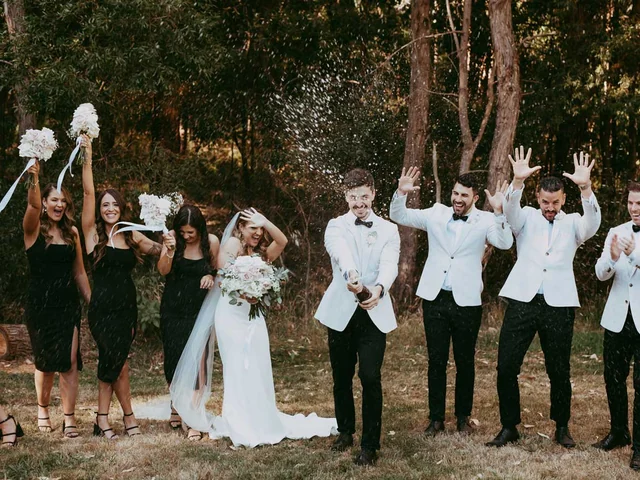 Bridal party celebrating on the lawn among the gum trees