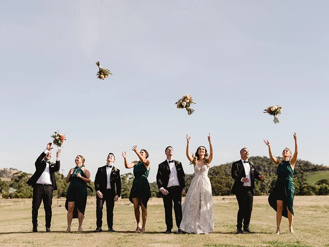 Bridal party throw their bouquets on the paddock