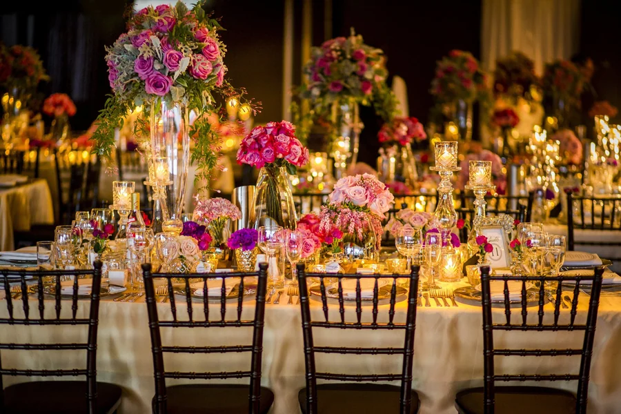Celebrating In Style &mdash; a long banquet table under tall floral arrangements