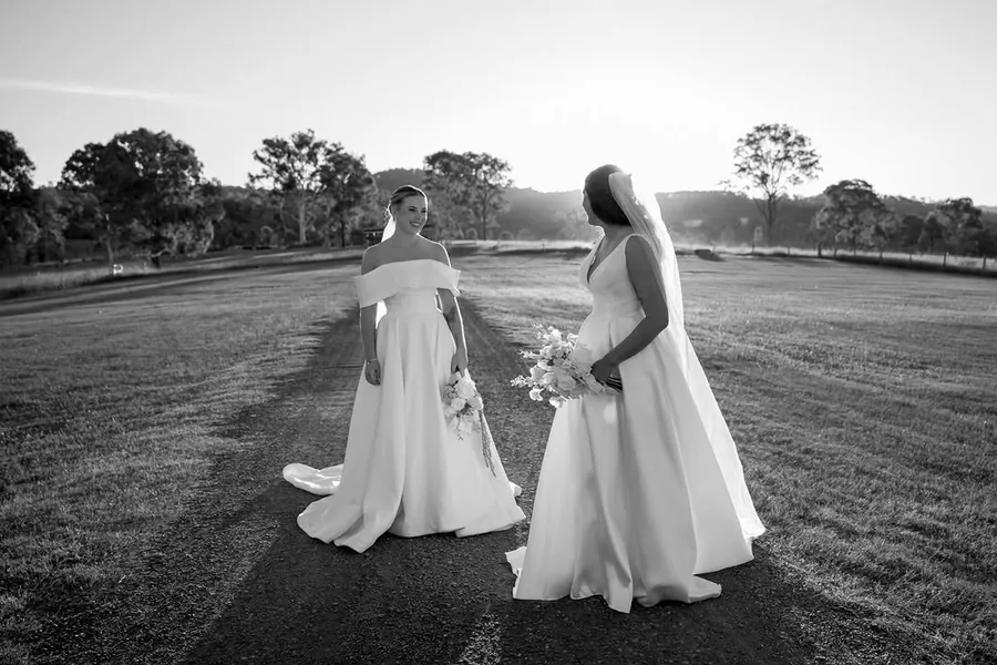 Hitch Perfect — two brides walking together, photographed in black and white