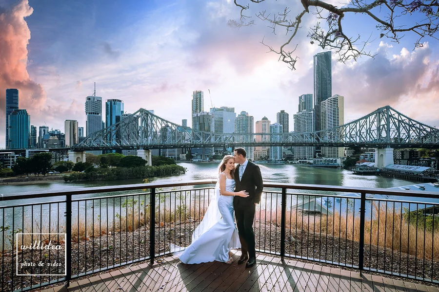 Willidea Studio &mdash; a couple on the river boardwalk with the Brisbane skyline behind
