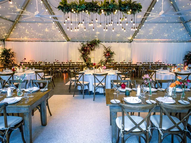 In The Grove — marquee reception mixing round and timber tables
