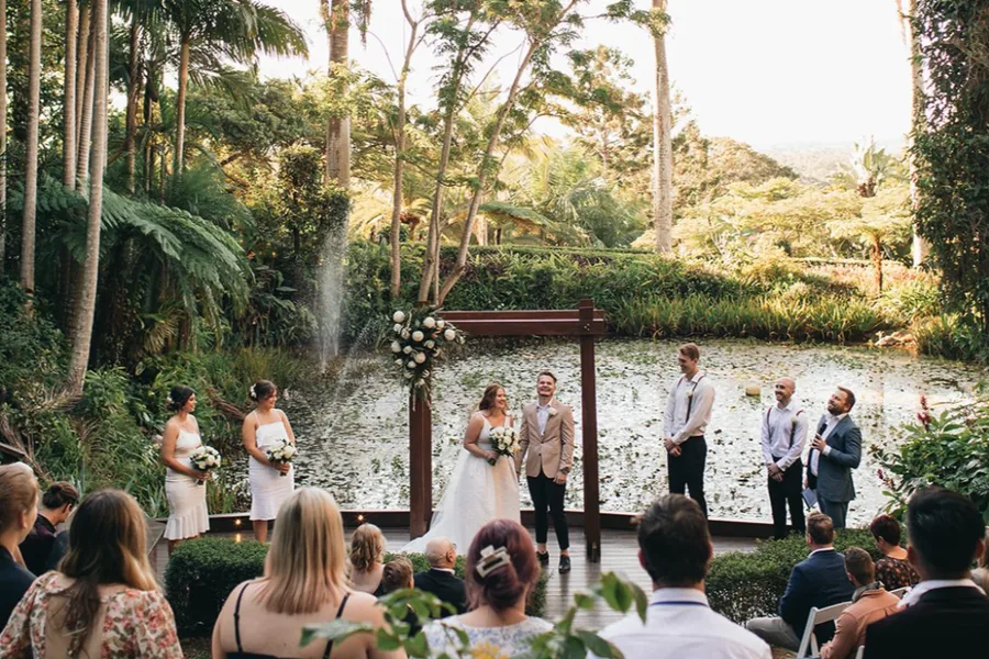 The Amphitheatre at Rainforest Gardens, tiered timber seating amid a canopy of palms with a deck over the pond
