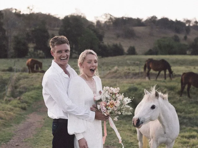A bride and groom with a white horse on a farm track at Wallaringa Farm
