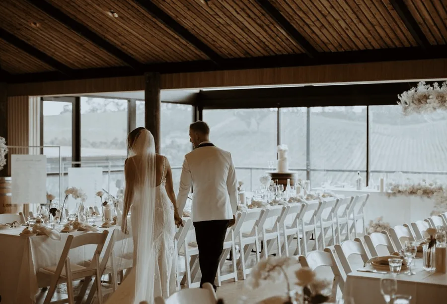 Longview Vineyard — the couple entering the reception, the vineyard through the glass
