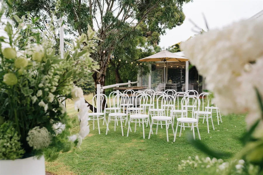 Lost Phoenix Farm &mdash; ceremony chairs and florals set out on the lawn