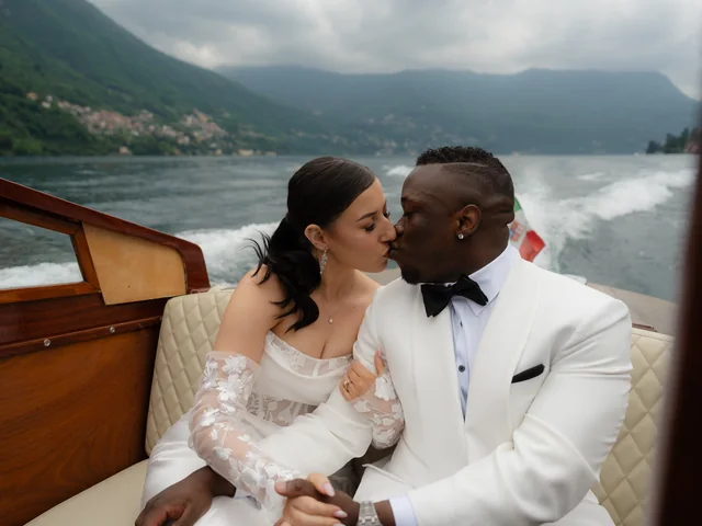 Newlyweds share a kiss on a boat on Lake Como, the groom in a LaMilago dinner jacket
