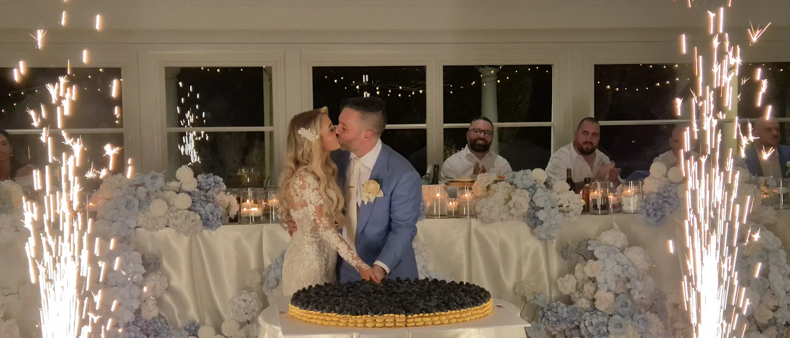 Couple kissing at the cake cutting between cold-spark fountains
