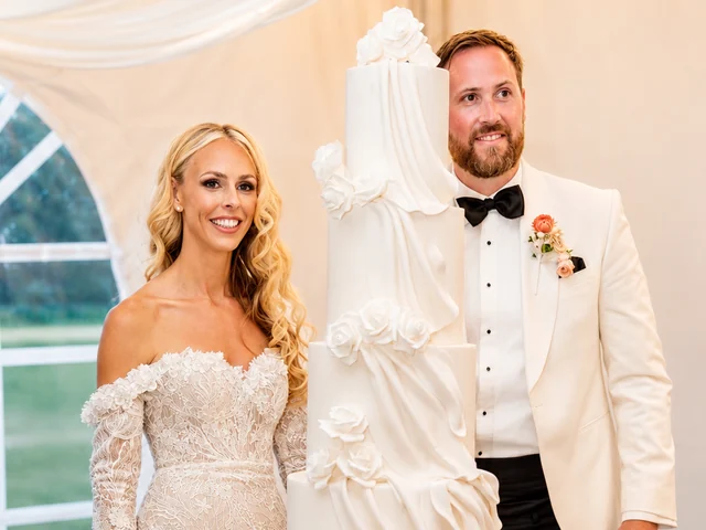 Couple beside a sculptural wedding cake inside the marquee at Adeline Estate