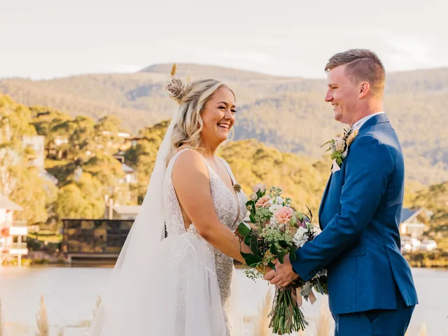 A Shot Above The Rest Photography: Bride and groom by the water with hills behind