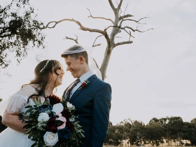 A Shot Above The Rest Photography: Bride and groom laugh together under a bare tree