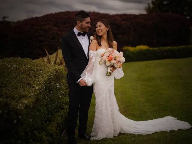 ATEIA Photography & Video: Bride and groom with her peach bouquet on a garden lawn at dusk