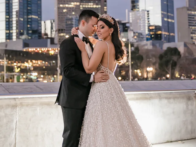 ATEIA Photography & Video: Couple embrace on the Southbank promenade with the Melbourne skyline behind