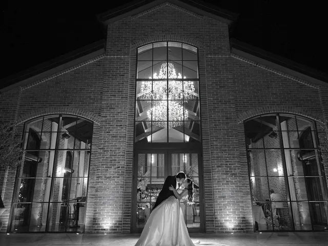 LM Images: Black and white portrait of the couple at night before a lit brick chapel
