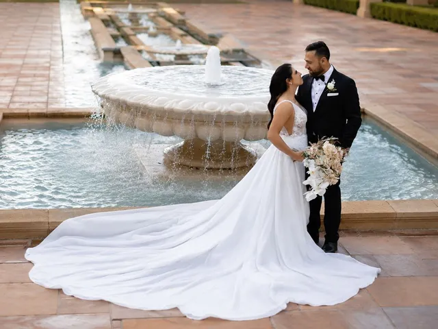 LM Images: Bride and groom beside a tiled fountain, her train spread across the paving
