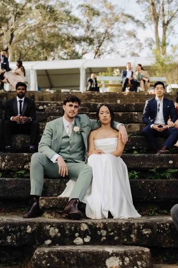 Fable Weddings: Bride and groom seated on stone steps with their bridal party