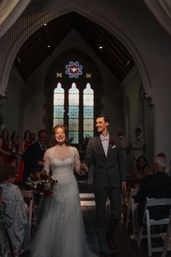 Fable Weddings: Newlyweds walking down the aisle of a stone chapel