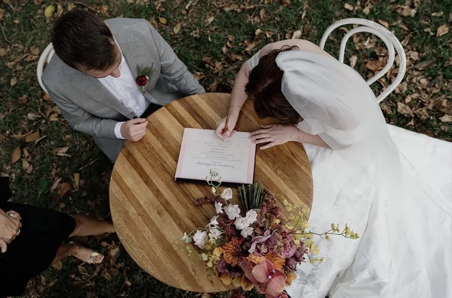 A Celebration Day: signing the register at a timber table