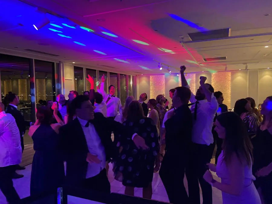 Wedding DJ Hire: a packed dance floor under coloured lights