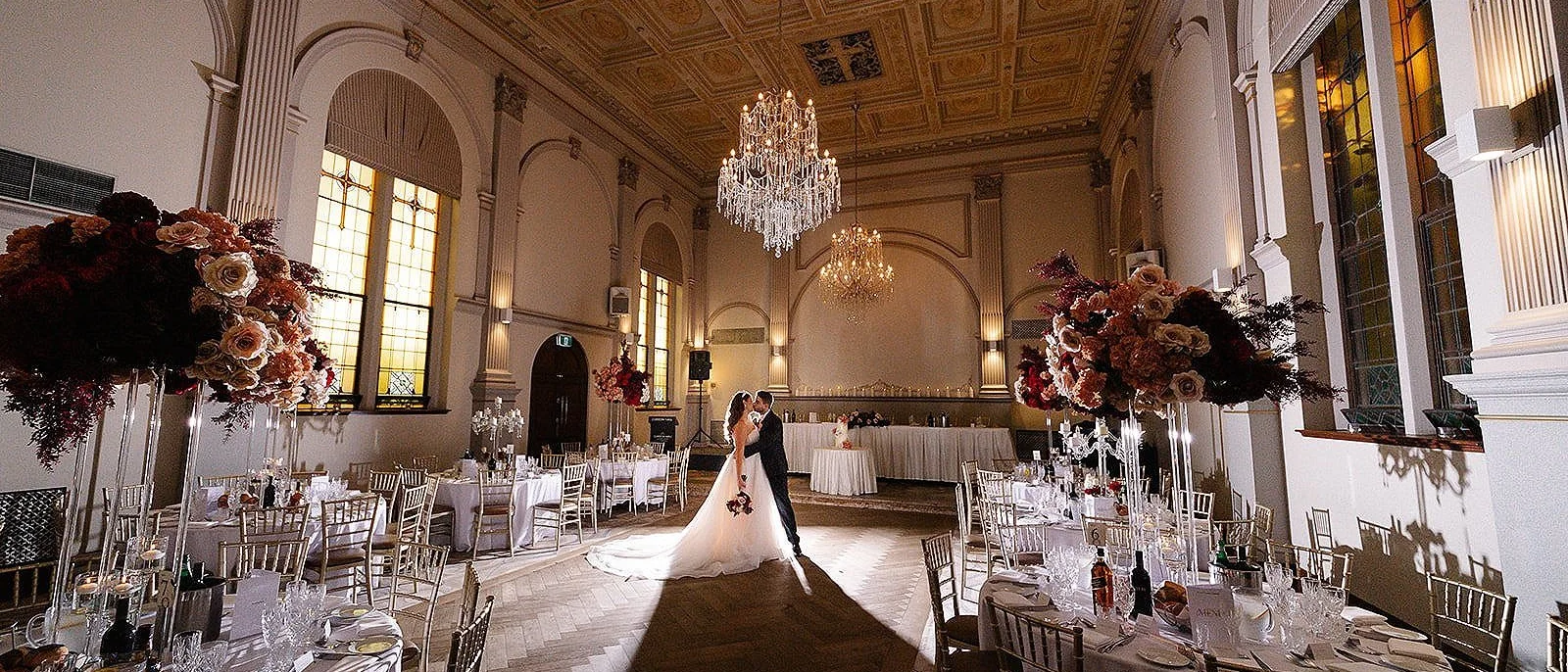 Jazzy Photography, Sydney wedding photographer: couple sharing a kiss in a chandelier-lit reception hall