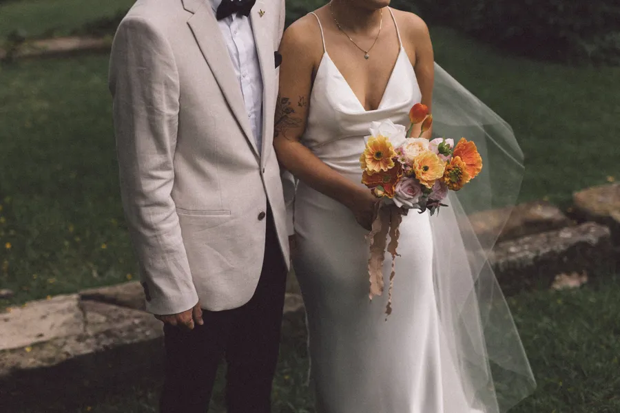 Rogue Weddings: the bride holding an orange and yellow bouquet