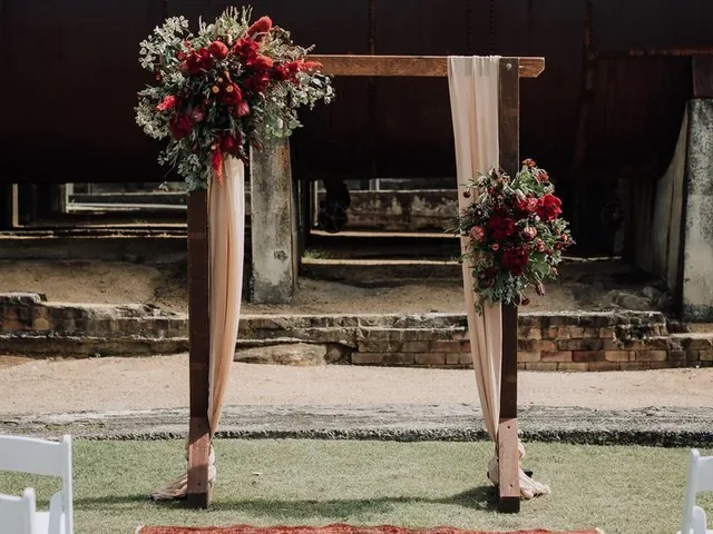 Lovesick Weddings: Wooden arch with red florals and a rug for the aisle