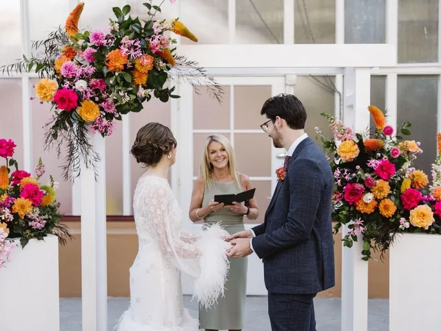 Lovesick Weddings: Ceremony under a white arbour with bright floral arrangements