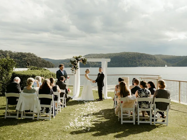 Lovesick Weddings: Waterfront ceremony with guests seated in white chairs
