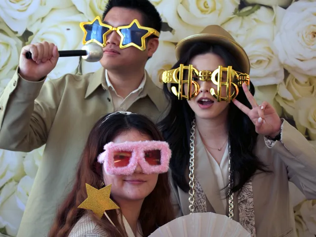 Sydney DJ & MC Services: Guests in star and dollar-sign glasses at the photo booth white rose backdrop