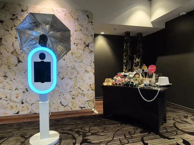 Sydney DJ & MC Services: Photo booth with a glowing ring light, white rose backdrop and props table