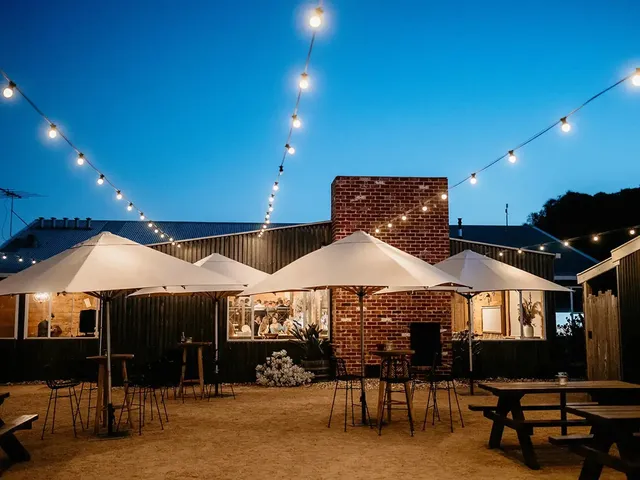 The Shearing Shed: The Courtyard at night with market umbrellas and festoon lights