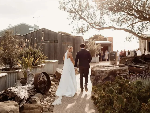 The Shearing Shed: Couple walking past the rustic sheds and garden