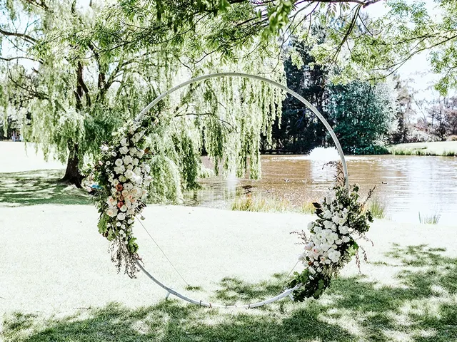 Floral hoop arch under the willow tree by the lake