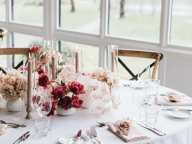 Round table with pink florals and candles by the conservatory windows